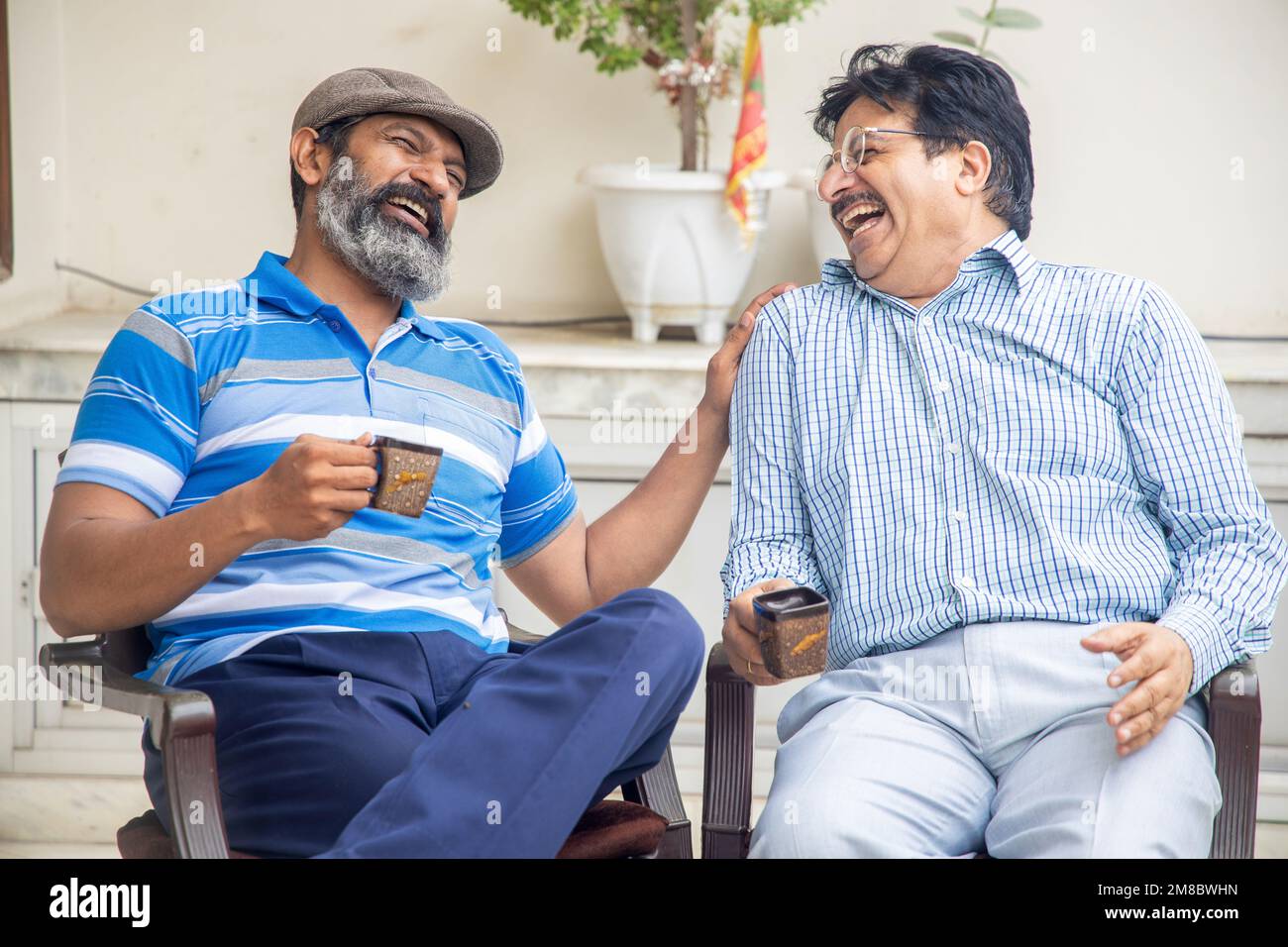 Happy indian mature friends enjoying morning tea or coffee together. Domestic or retirement life. Stock Photo