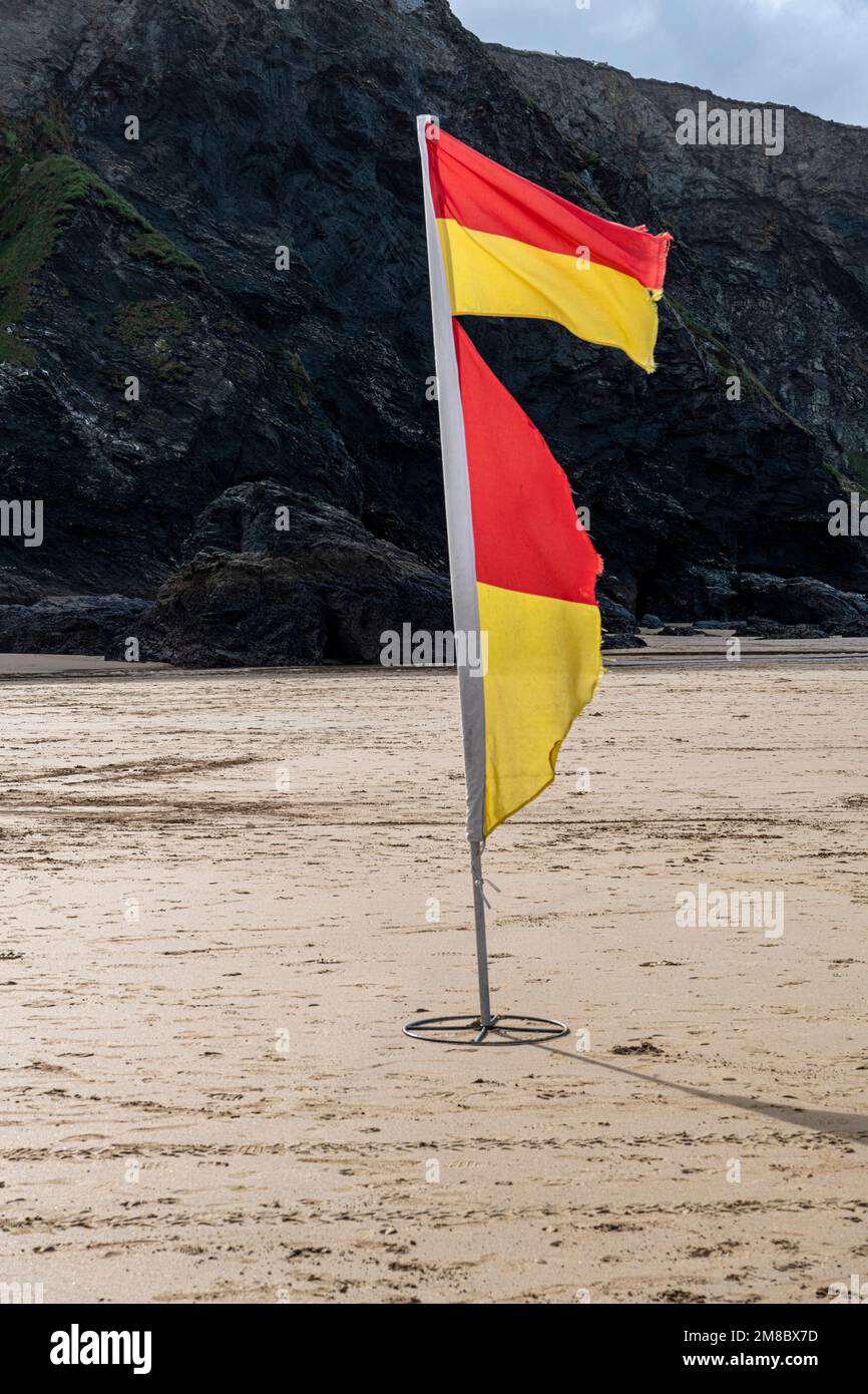 Red and yellow flag on Mawgan Porth beach, Cornwall Stock Photo