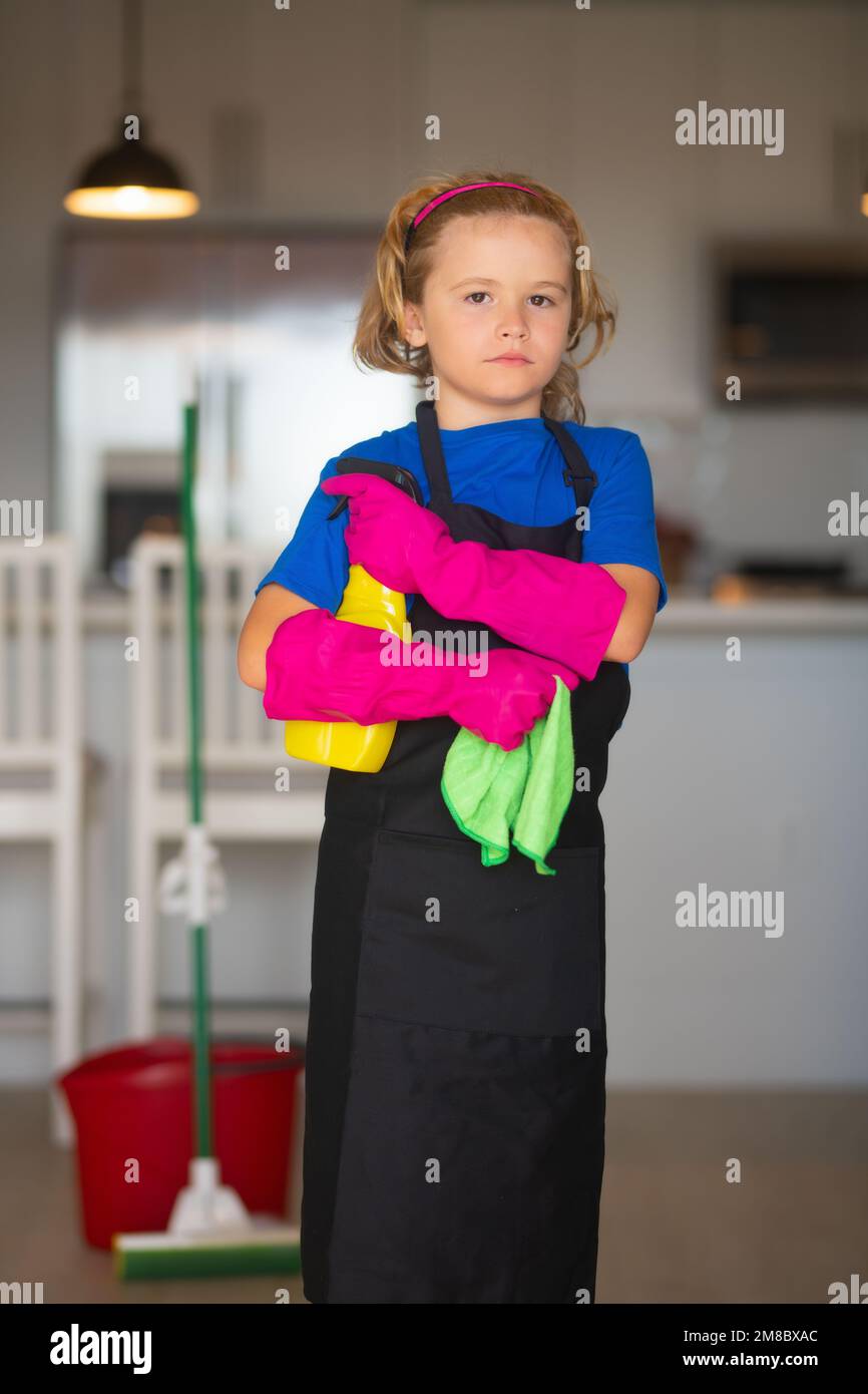 Child use duster and gloves for cleaning. Funny child mopping house. Cleaning accessory, cleaning supplies. Housekeeping and home cleaning. Stock Photo