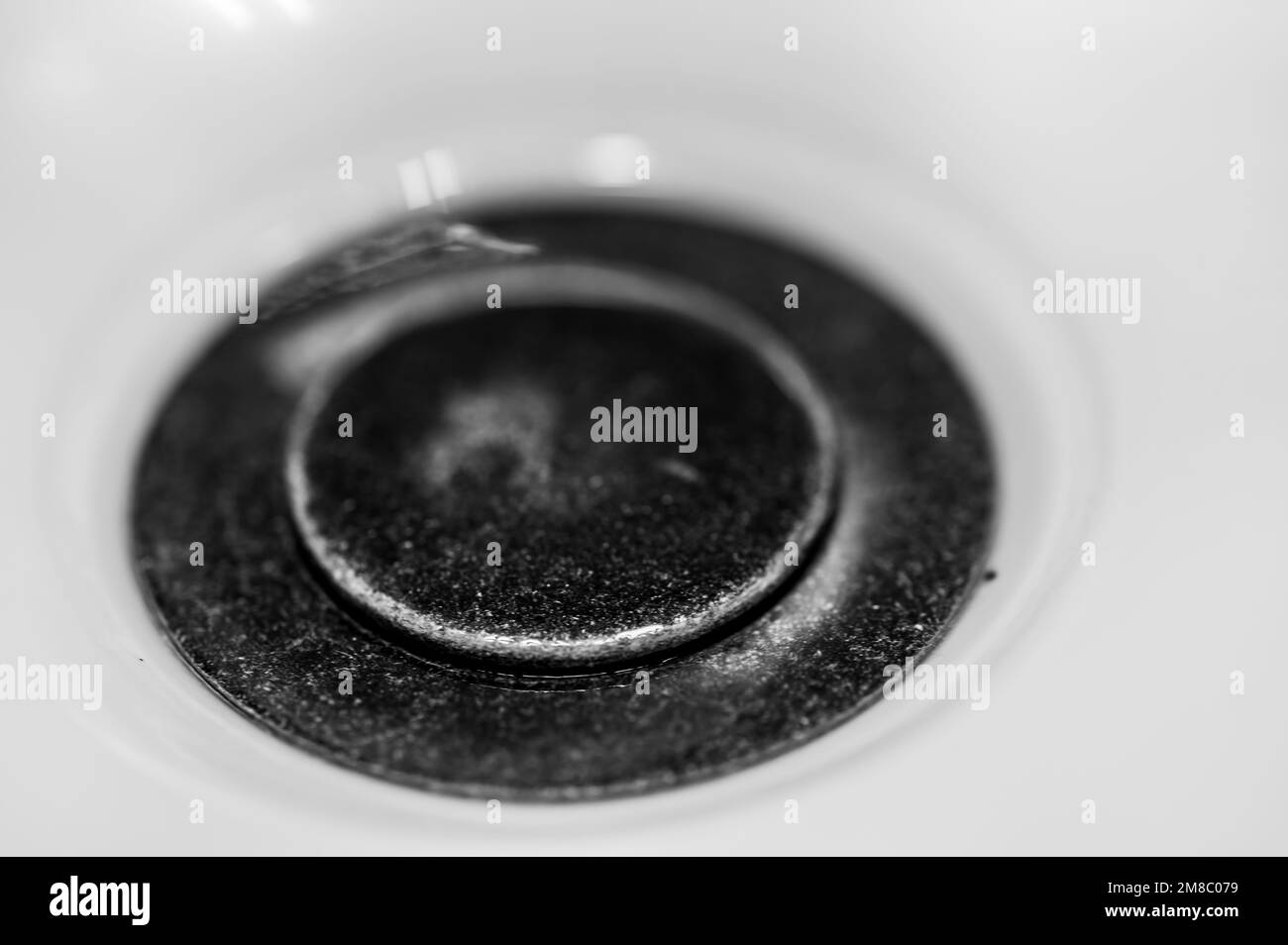 Selective focus on a closed bronze sink drain. Stock Photo