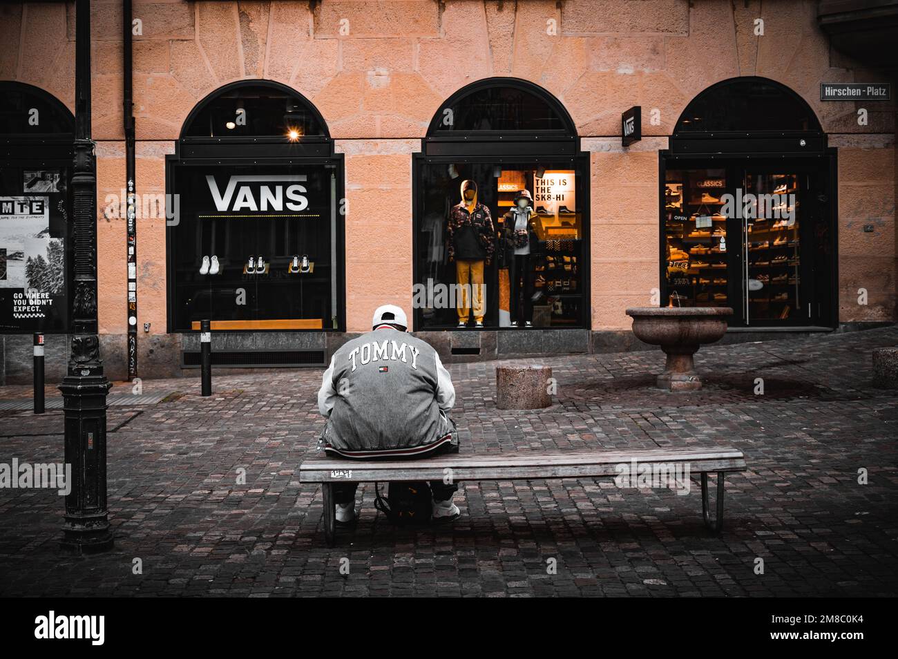 A man sitting on a bench against the "Vans" store in Zurich Stock Photo -  Alamy