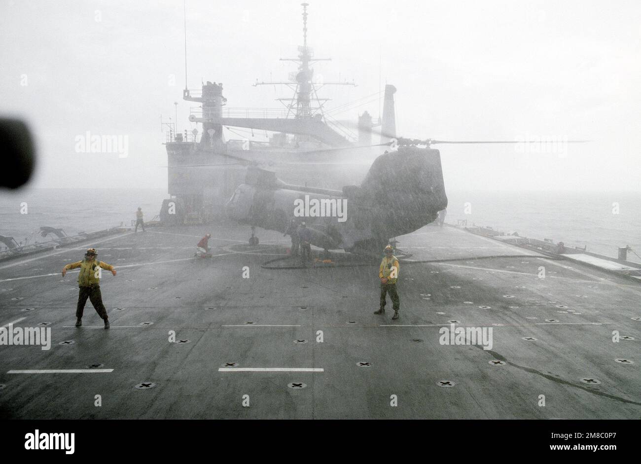 Fog obscures a CH-46E Sea Knight helicopter of Marine Medium Helicopter Squadron 163 (HMM-163) on the flight deck of the amphibious transport dock USS VANCOUVER (LPD-2) during the joint Thai/U.S. exercise Thalay Thai '89. Subject Operation/Series: THALAY THAI '89 Country: Gulf Of Thailand Stock Photo