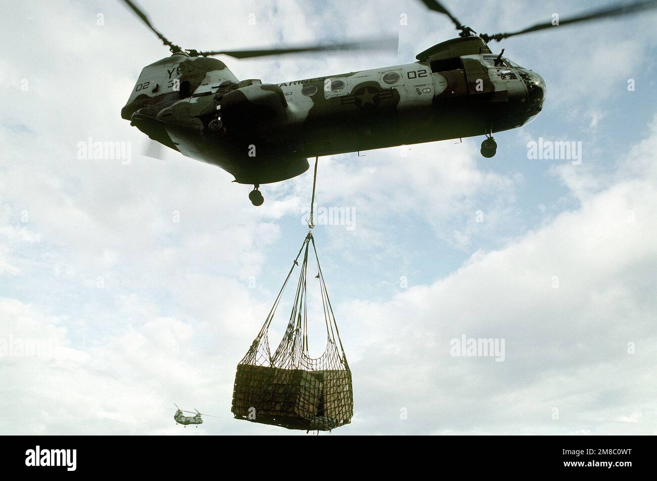 A CH-46E SEA Knight helicopter of Marine Medium Helicopter Squadron 163 (HMM-163) carries supplies on a sling during the joint Thai/U.S. exercise Thalay Thai '89. Subject Operation/Series: THALAY THAI '89 Country: Thailand (THA) Stock Photo