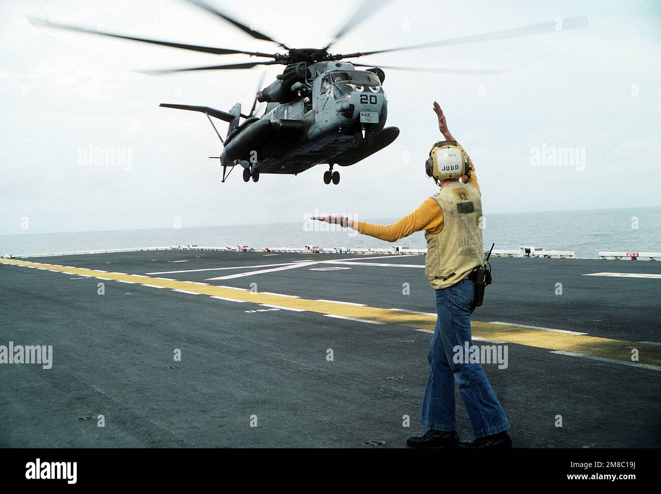 A flight deck director aboard the amphibious assault ship USS TARAWA (LHA-1) guides in a CH-53E Super Stallion helicopter during the combined Thai/U.S. joint Exercise Thalay Thai '89. The helicopter is assigned to Marine Medium Helicopter Squadron 163 (HMM-163), the reinforced aviation combat element of the 11th Marine Expeditionary Unit (11th MEU). Subject Operation/Series: THALAY THAI '89 Country: Gulf Of Thailand Stock Photo