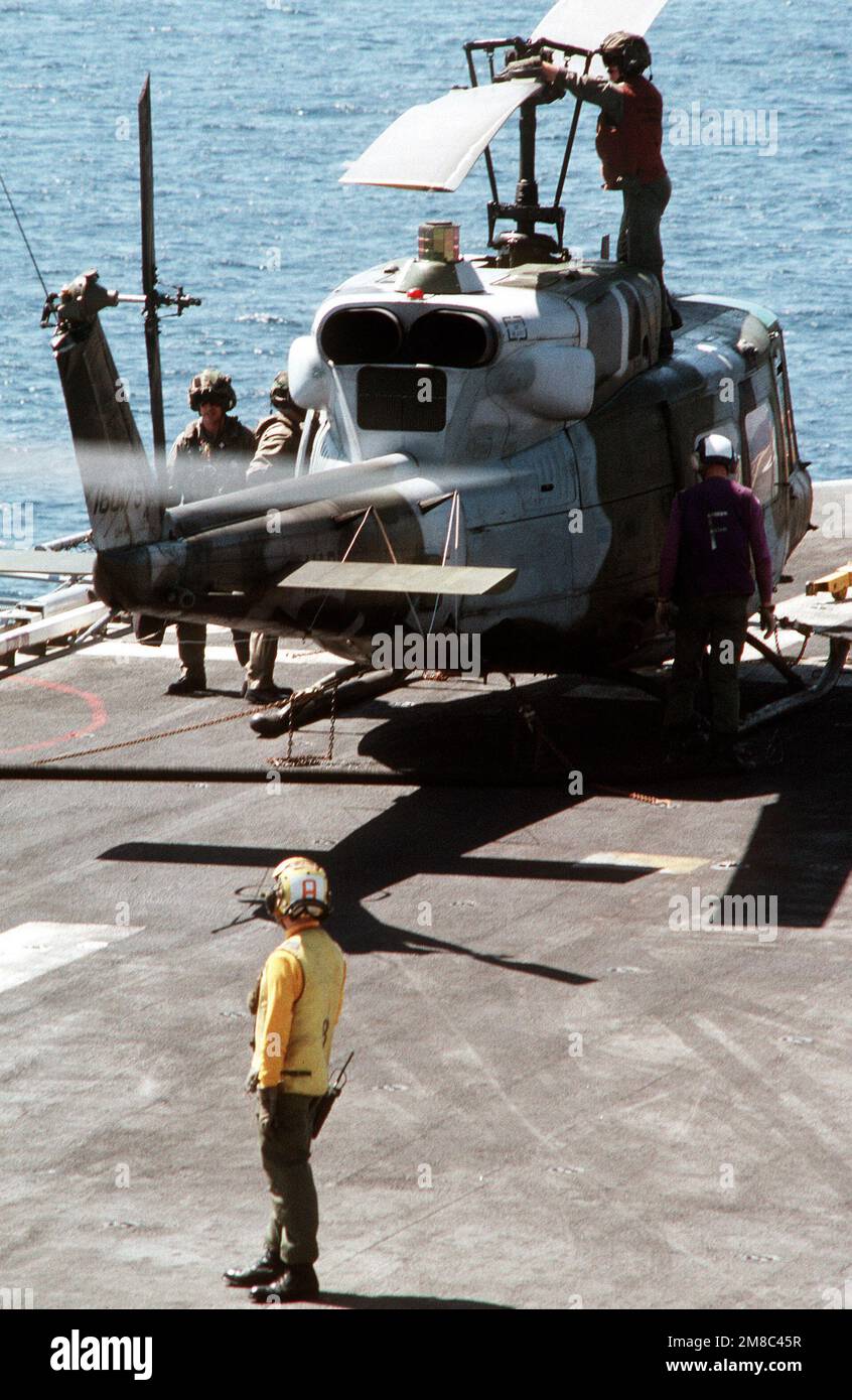A Marine UH-1N Iroquois helicopter is refueled and tied down on the ...