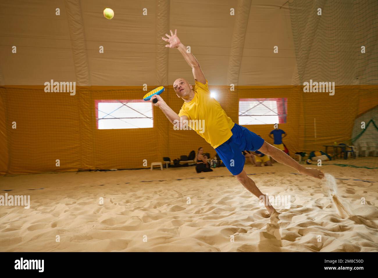Man hits a tennis ball before it hits the sand Stock Photo Alamy
