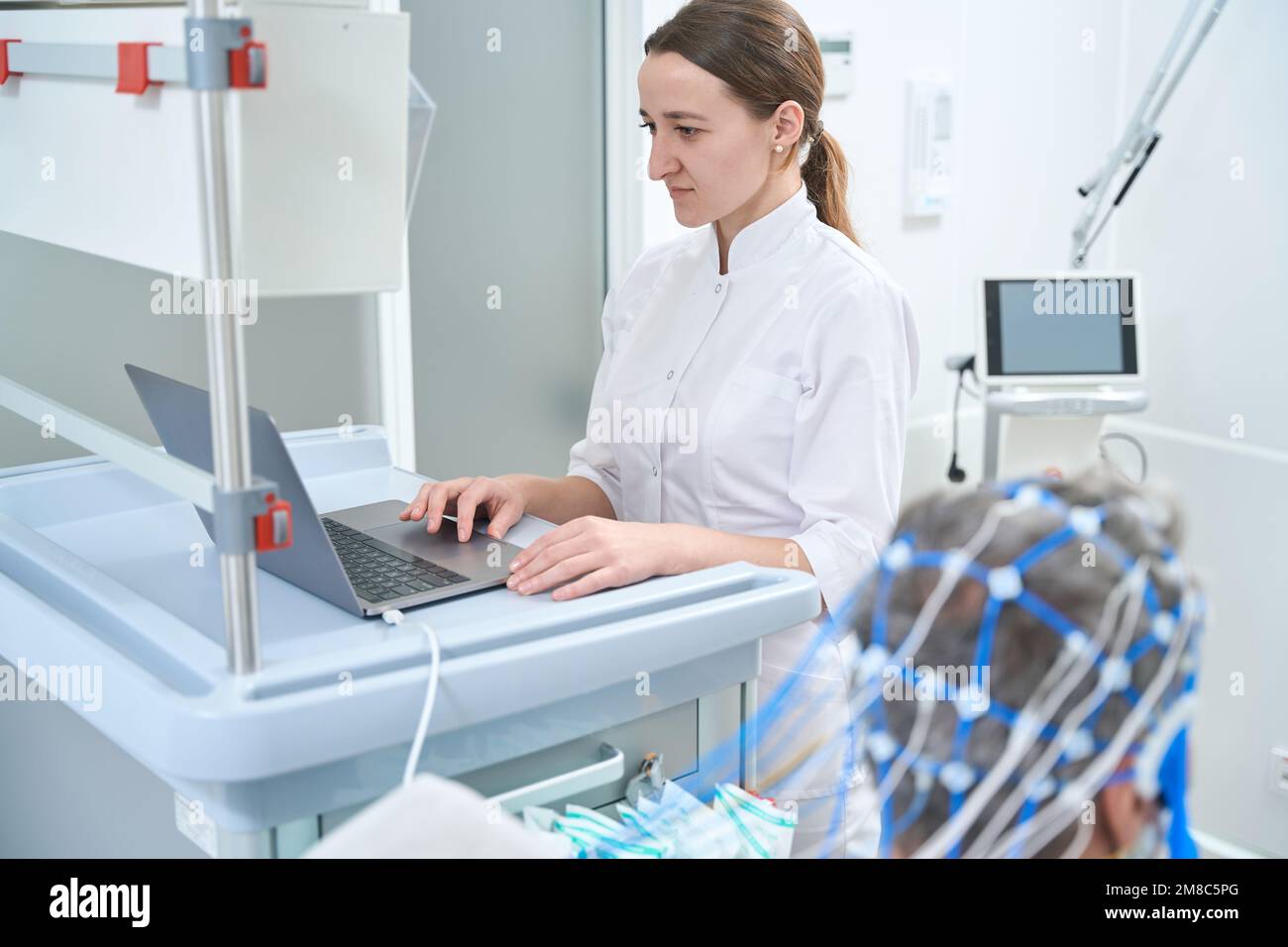 Young female doctor is performing EEG - electroencephalography Stock ...