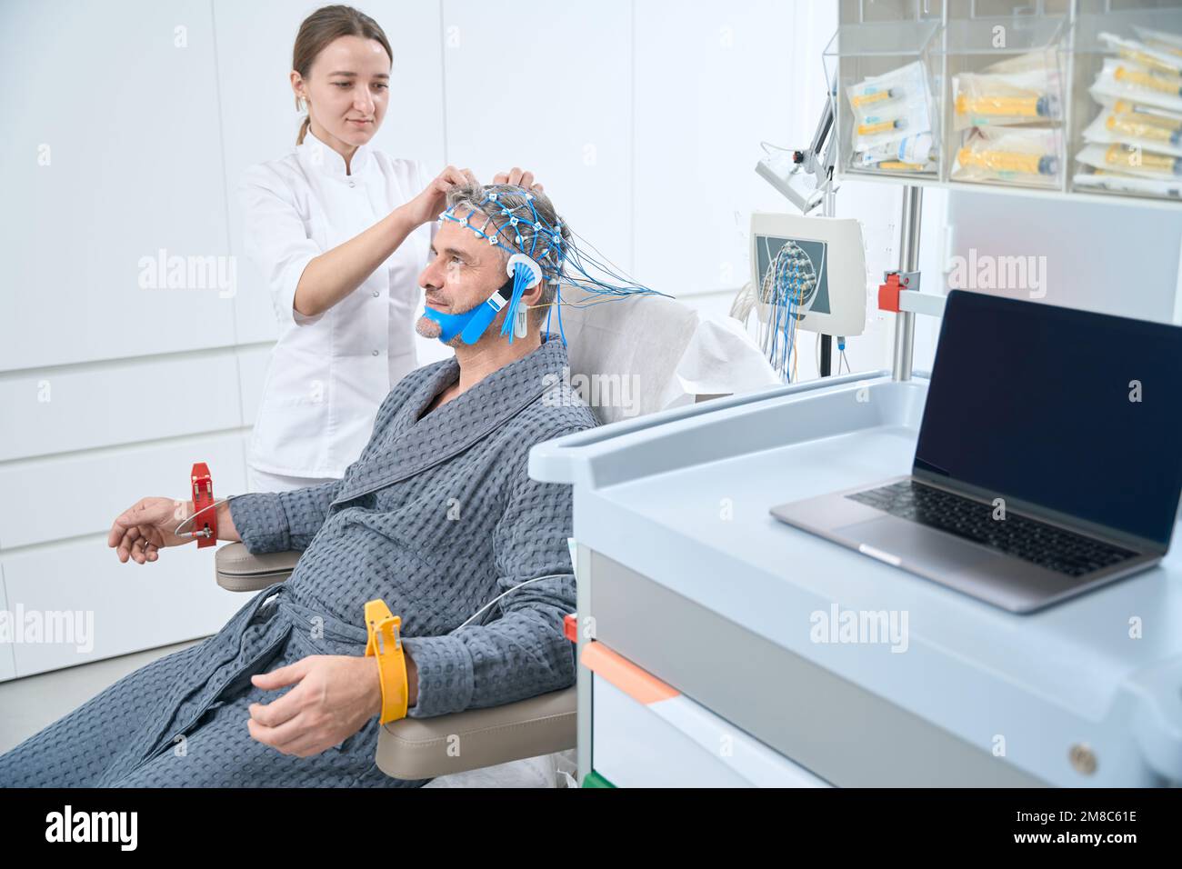 Employee of a medical clinic is diagnosing EEG electroencephalography