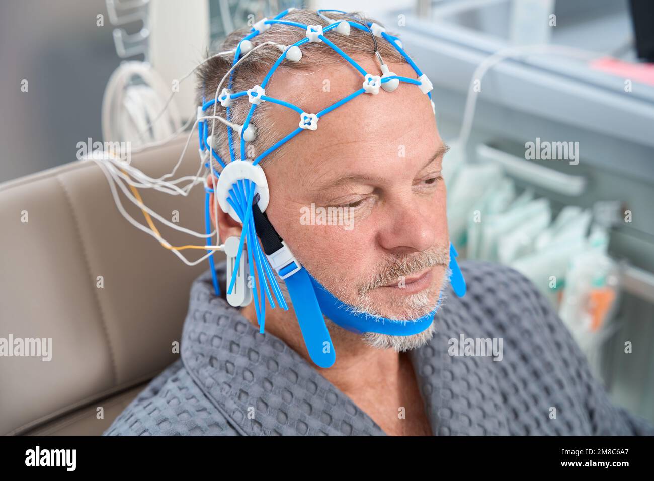 Man has cap of electrodes for encephalography on his head Stock Photo