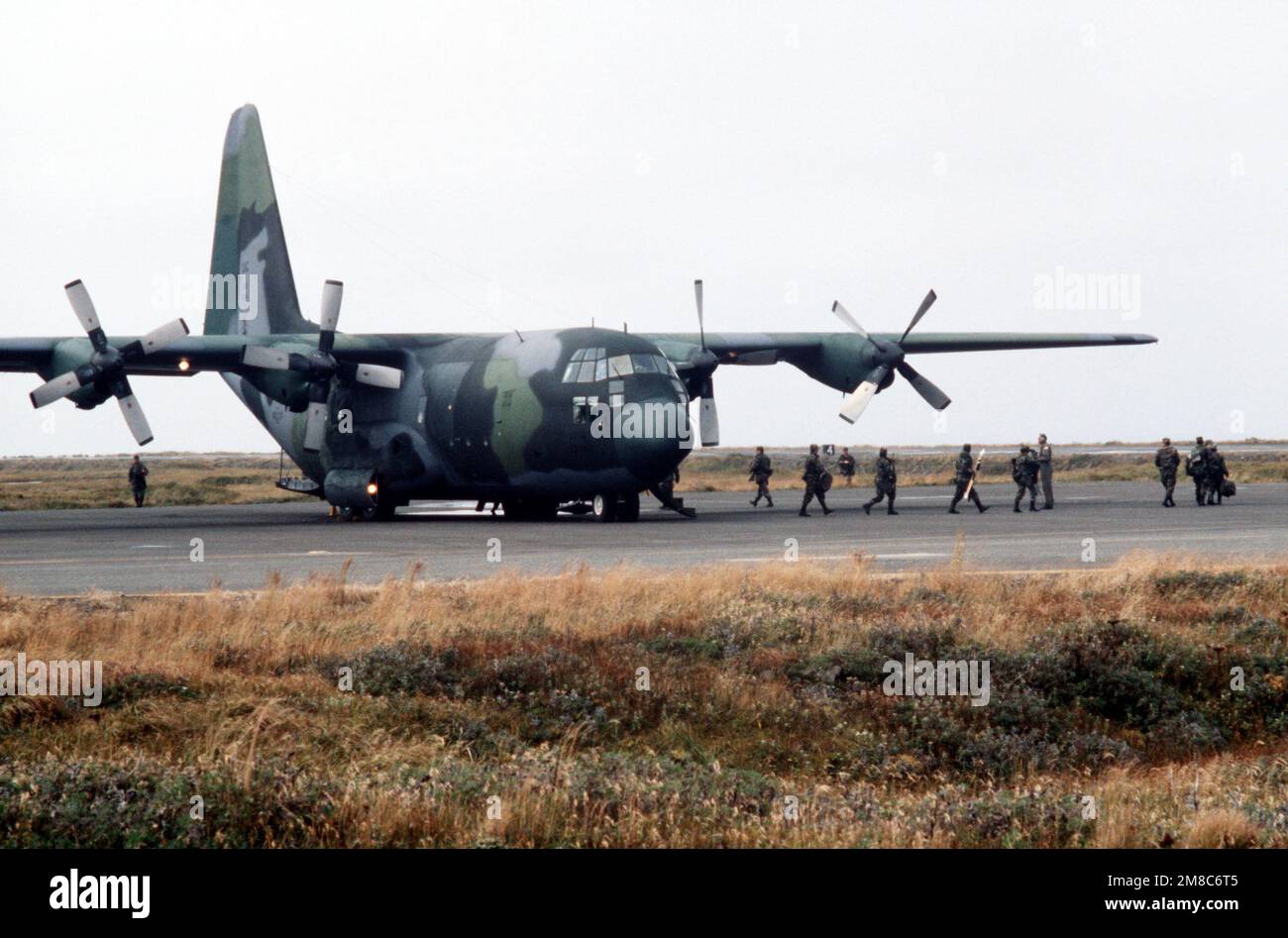Members of Co. C, 2nd Bn., 297th Infantry Group (Scout), Alaska National Guard, disembark from an Air Force C-130 Hercules aircraft after arriving to take part in exercise Kernal Potlatch '89. Subject Operation/Series: KERNAL POTLATCH '89 Base: Amchitka Island State: Alaska (AK) Country: United States Of America (USA) Stock Photo