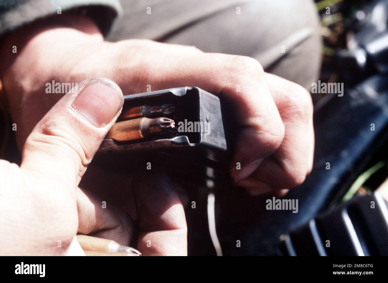 An Alaska National Guardsman loads a blank 5.56mm cartridge into a magazine during exercise Kernal Potlatch '89. Subject Operation/Series: KERNAL POTLATCH '89 Base: Amchitka Island State: Alaska (AK) Country: United States Of America (USA) Stock Photo