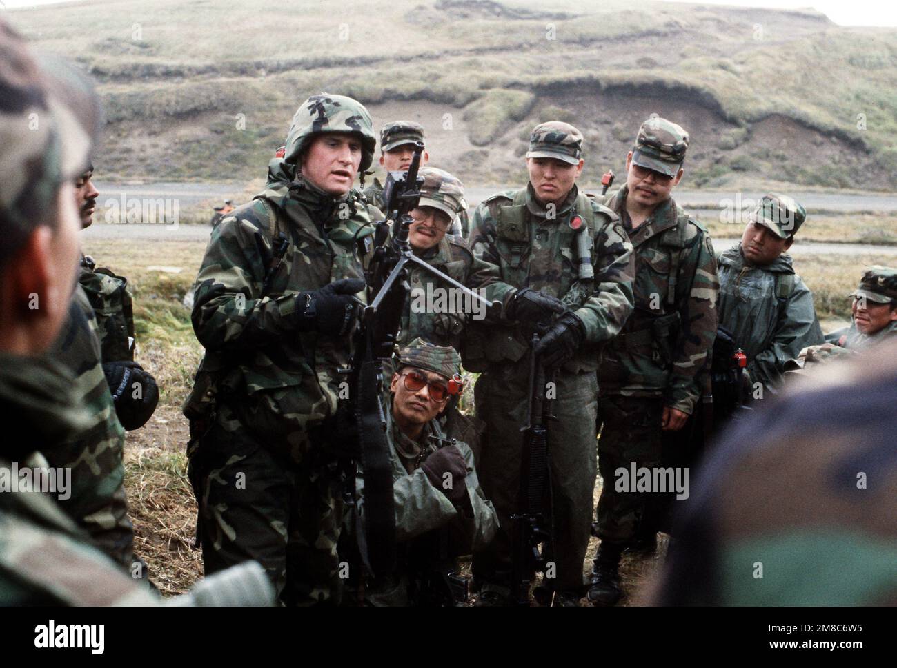 Marine 1LT John Wills conducts a class on the M-249 squad automatic weapon for members of Co. C, 2nd Bn., 297th Infantry Group (Scout), Alaska National Guard, scans the area for aggressor forces during exercise Kernal Potlatch '89. Subject Operation/Series: KERNAL POTLATCH '89 Base: Amchitka Island State: Alaska (AK) Country: United States Of America (USA) Stock Photo