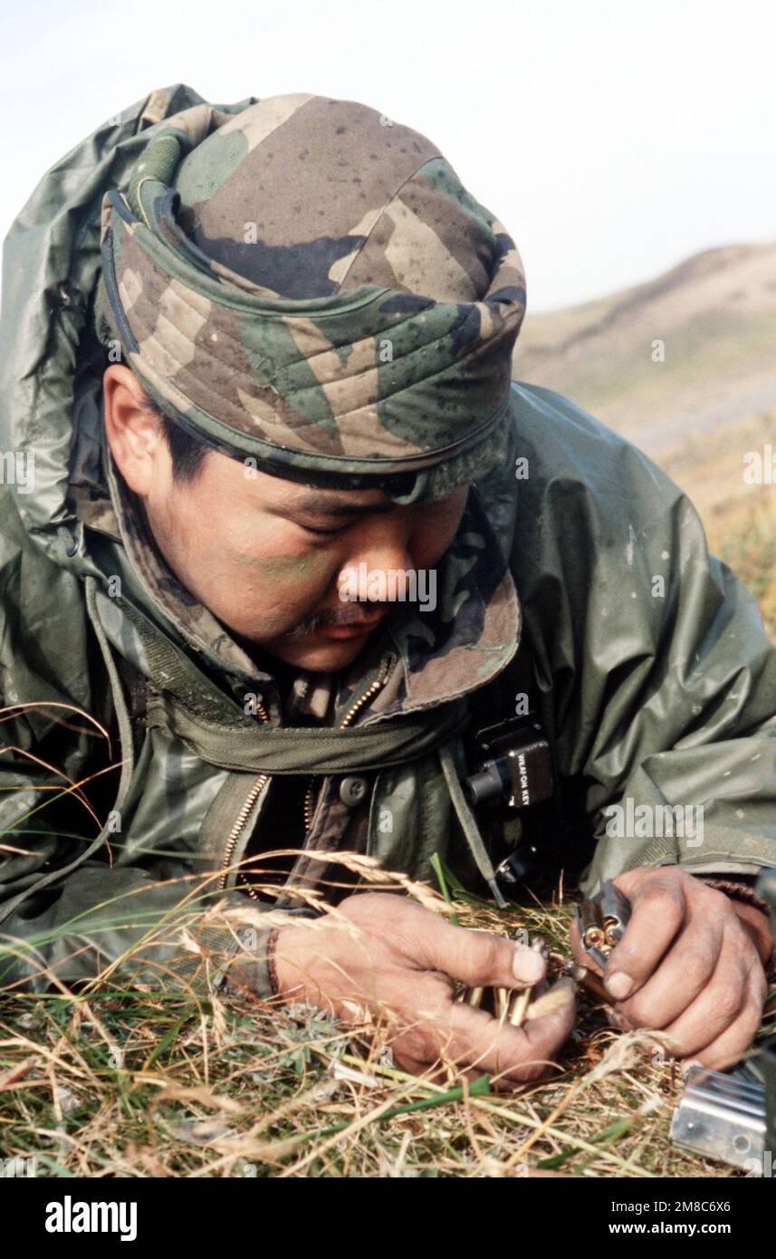 SGT Paul Mayie, a member of Co. C, 2nd Bn., 297th Infantry Group (Scout), Alaska National Guard, reloads the magazines for his M-16 rifle during exercise Kernal Potlatch '89. Subject Operation/Series: KERNAL POTLATCH '89 Base: Amchitka Island State: Alaska (AK) Country: United States Of America (USA) Stock Photo