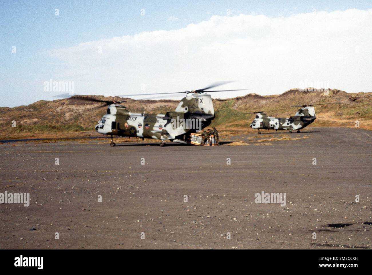 Marines remove a pallet of supplies from a CH-46E Sea Knight helicopter from Marine Medium Helicopter Squadron 166 (HMM-166) during exercise Kernal Potlatch '89. The Marines are acting as aggressor forces against an Alaska National Guard unit. Subject Operation/Series: KERNAL POTLATCH '89 Base: Amchitka Island State: Alaska (AK) Country: United States Of America (USA) Stock Photo