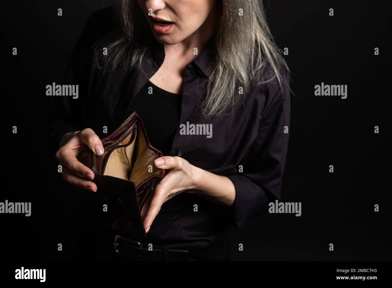 Unhappy bankrupt woman with empty wallet. Young woman shows her empty wallet. Bankruptcy. Stock Photo