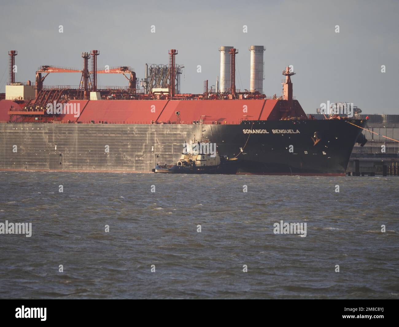 Sheerness, Kent, UK. 13th Jan, 2023. UK gas prices forecast to drop: two LNG gas ships seen berthed at National Grid's Grain LNG facility (Europe's largest storage facility) this afternoon pictured from Sheerness, Kent. Red hulled vessel is Rias Baixas Knutsen, blue hulled vessel arrived this afternoon is Sonangol Benguela. Credit: James Bell/Alamy Live News Stock Photo