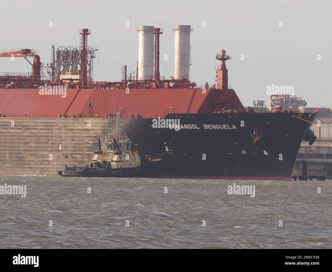 Sheerness, Kent, UK. 13th Jan, 2023. UK gas prices forecast to drop: two LNG gas ships seen berthed at National Grid's Grain LNG facility (Europe's largest storage facility) this afternoon pictured from Sheerness, Kent. Red hulled vessel is Rias Baixas Knutsen, blue hulled vessel arrived this afternoon is Sonangol Benguela. Credit: James Bell/Alamy Live News Stock Photo