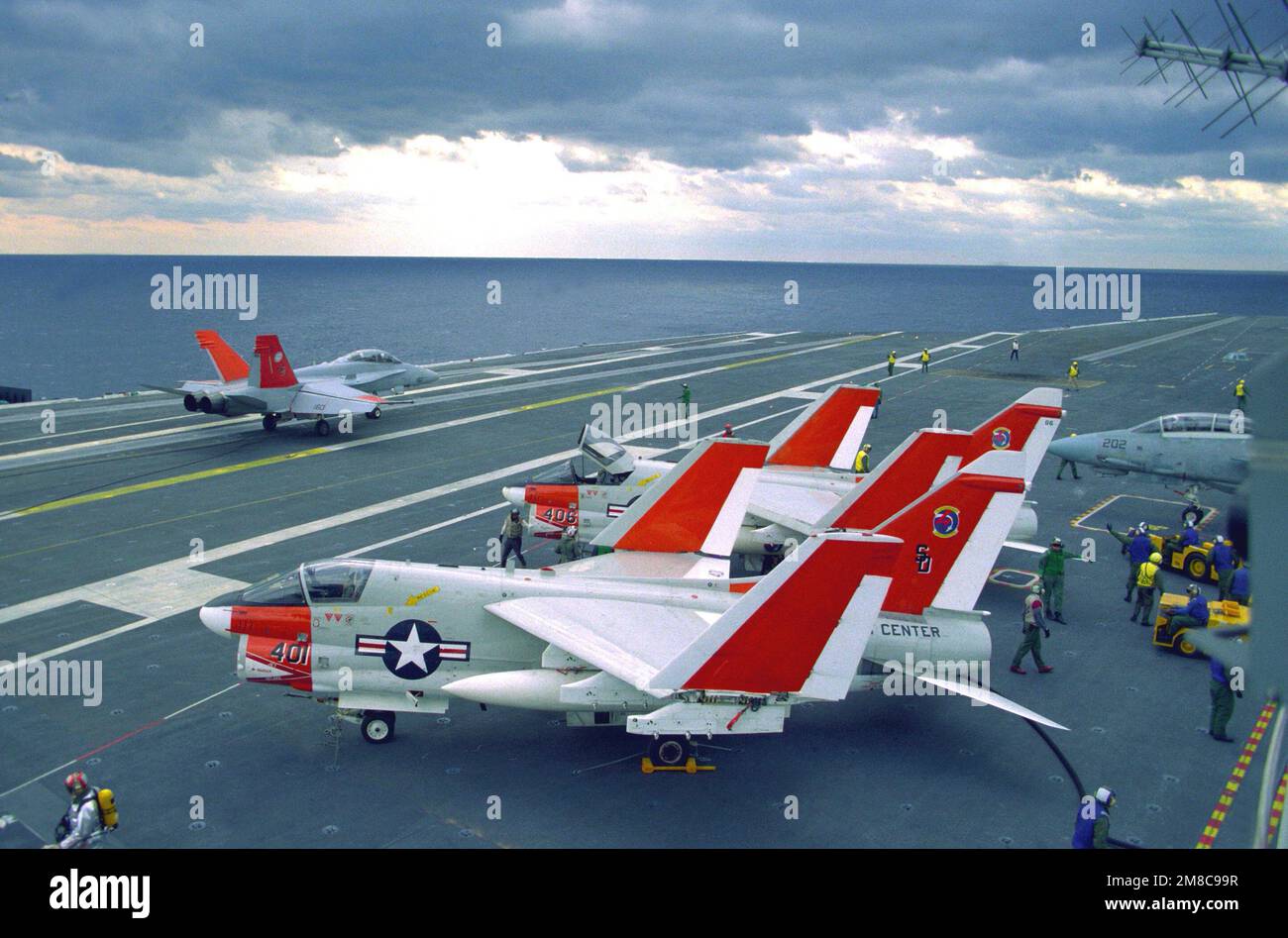 An F-18A Hornet aircraft is positioned on the flight deck of the nuclear-powered aircraft carrier USS ABRAHAM LINCOLN (CVN-72) shortly after landing. The Hornet, along with the two A-7E Corsair II aircraft parked on the sideline, are among several planes from the Patuxent River Flight Test Center aboard the carrier to test the vessel's flight deck capabilities. Country: Atlantic Ocean (AOC) Stock Photo