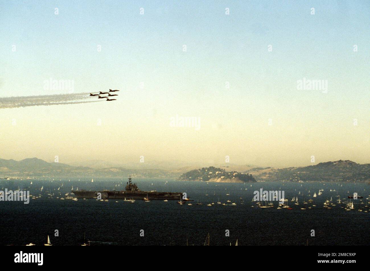 Six F/A-18 Hornet aircraft of the Navy Blue Angels flight demonstration squadron pass over the aircraft carrier USS INDEPENDENCE (CV-62) during an air show staged for Fleet Week. Base: San Francisco Bay State: California (CA) Country: United States Of America (USA) Stock Photo