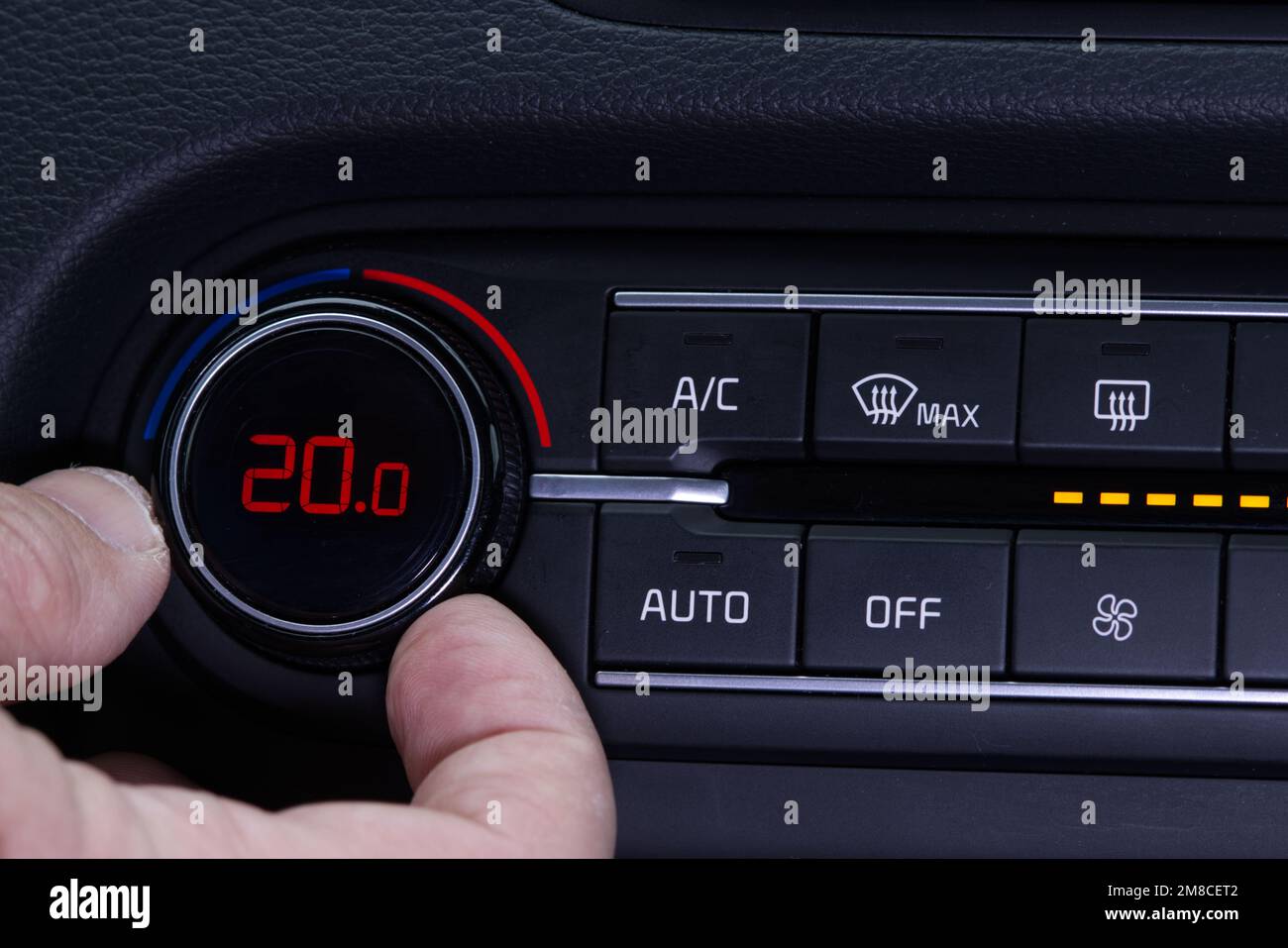Set up air conditioner in the car. Hand turns air conditioner ring. Display indicates 20.0 degree celsius temperature inside the car. Cooling air in t Stock Photo