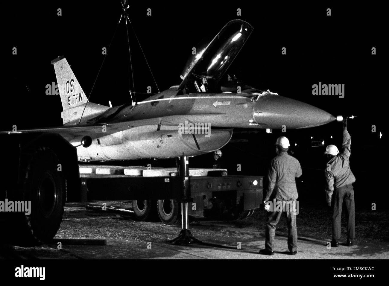 An F-16C Fighting Falcon aircraft from the 36th Tactical Fighter Squadron is lowered onto a flatbed trailer after being recovered from a runway following an emergency gear-up landing. Base: Osan Air Base Country: Republic Of Korea (KOR) Stock Photo