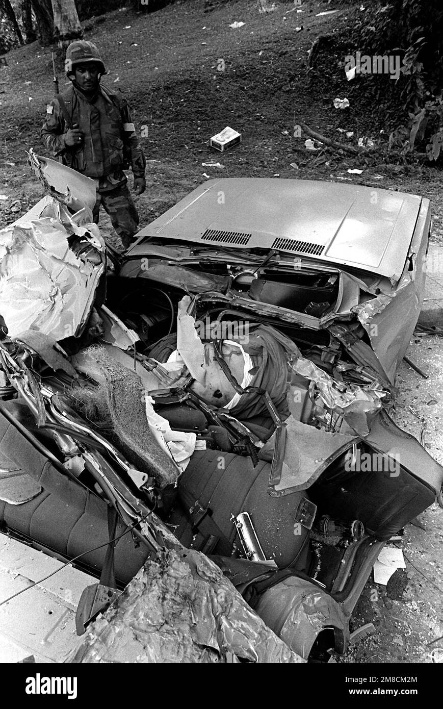 During the second day of Operation Just Cause, a U.S. Army soldier inspects an automobile that was used by the Panamanian Defense Force to transport weapons until it was run over by an American armored personnel carrier. Subject Operation/Series: JUST CAUSE Base: Panama City Country: Panama (PAN) Stock Photo