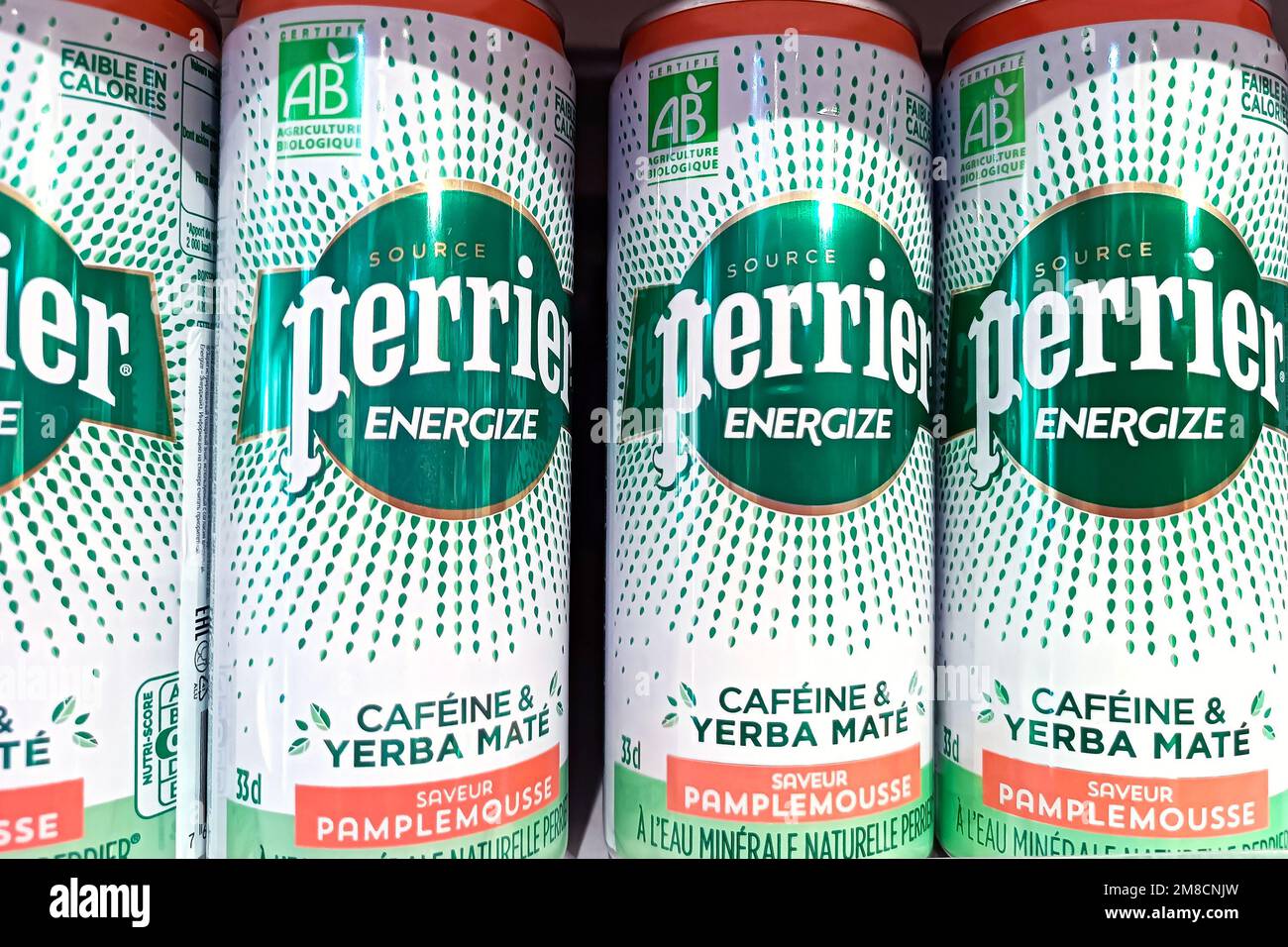 DUSHANBE, TAJIKISTAN - AUGUST 12, 2022: Green Perrier Energize Pamplemousse carbonated water cans on the display shelf in the grocery store close up. Stock Photo