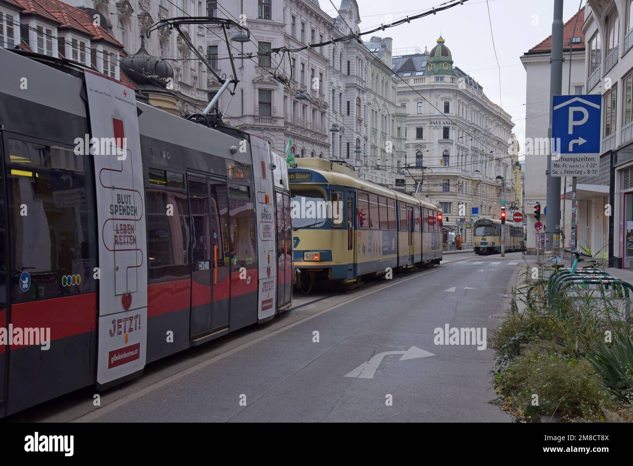 A Siemens ELIN Ultra Low Floor Electric tram operating alongside a Wiener Lokalbahn 100 series high floor tram in Vienna, Austria. December 2022 Stock Photo