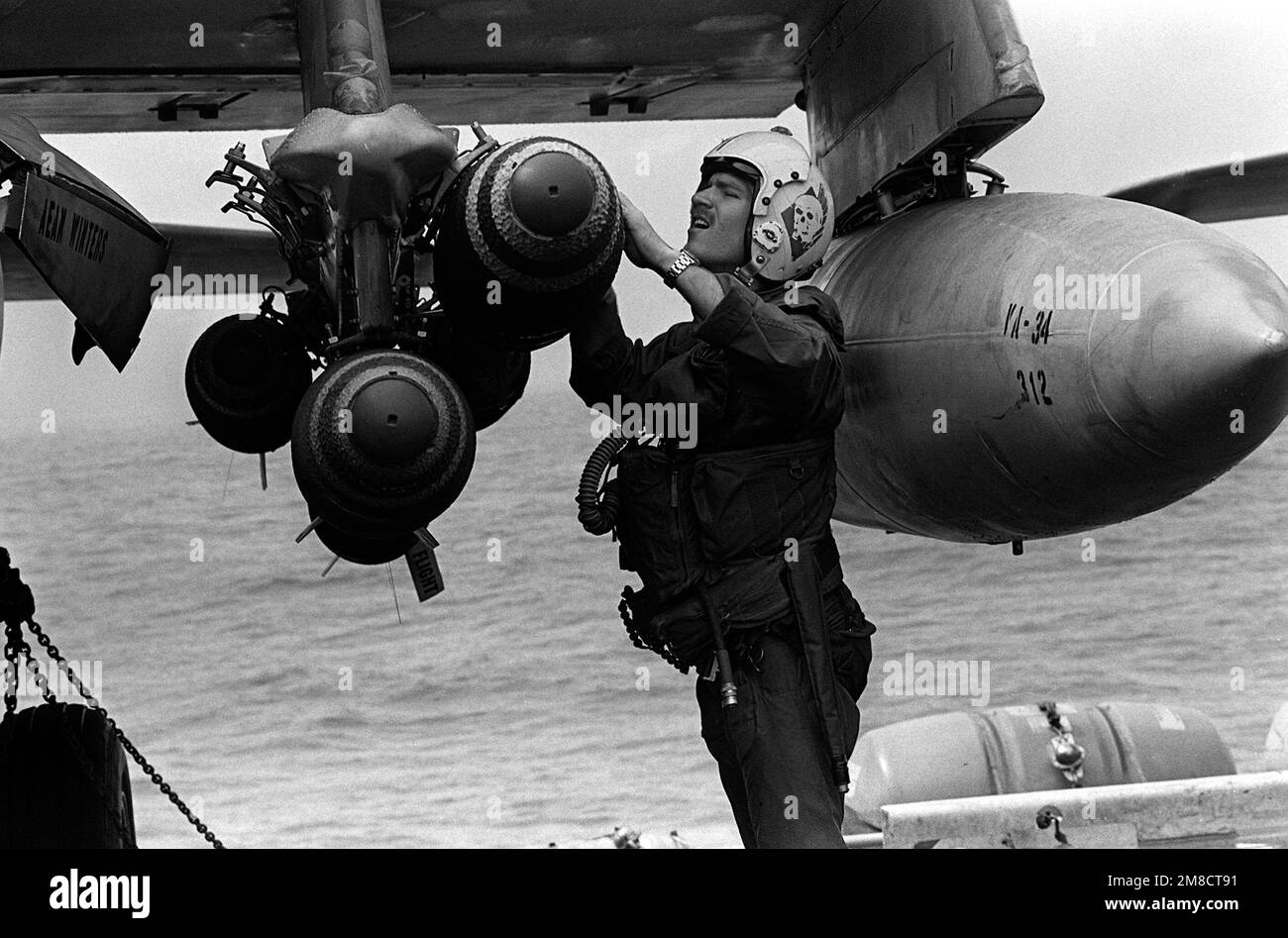 An Attack Squadron 34 (VA-34) pilot conducts a preflight check of the bombs hung on a wing pylon of his A-6E Intruder aircraft aboard the nuclear-powered aircraft carrier USS DWIGHT D. EISENHOWER (CVN-69) during Fleet Ex '90. Country: Atlantic Ocean (AOC) Stock Photo