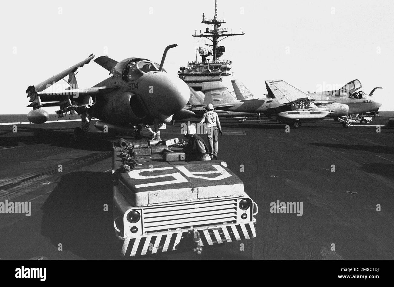 An MD-3A tow tractor is used to move an A-6E Intruder aircraft on the flight deck of the aircraft carrier JOHN F. KENNEDY (CV-67) during FLEET EX 1-90. Subject Operation/Series: FLEET EX 1-90 Country: Atlantic Ocean (AOC) Stock Photo