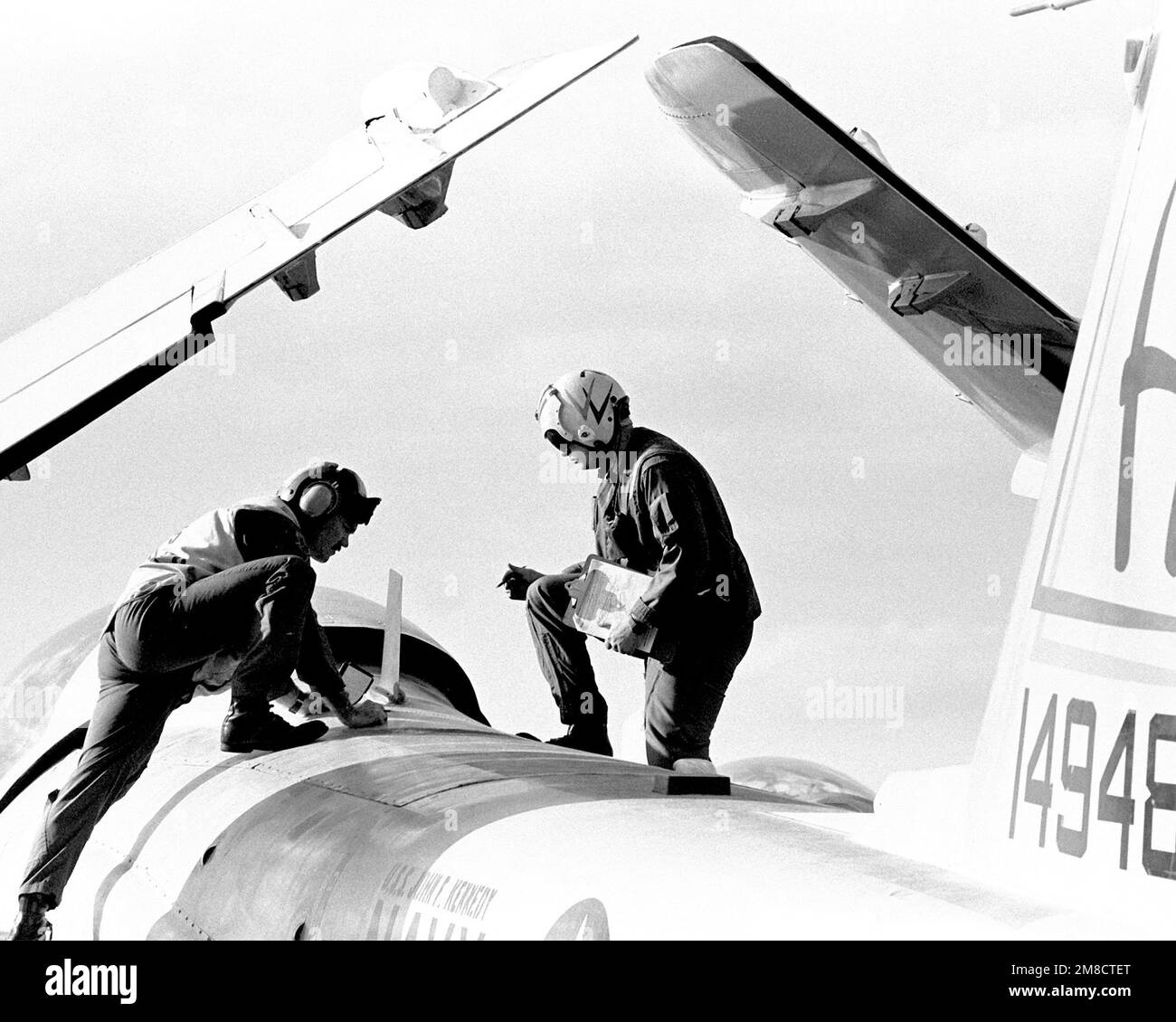 Two flight deck crew members inspect an A-6E Intruder aircraft aboard the aircraft carrier JOHN F. KENNEDY (CV-67) during FLEET EX 1-90. Subject Operation/Series: FLEET EX 1-90 Country: Atlantic Ocean (AOC) Stock Photo