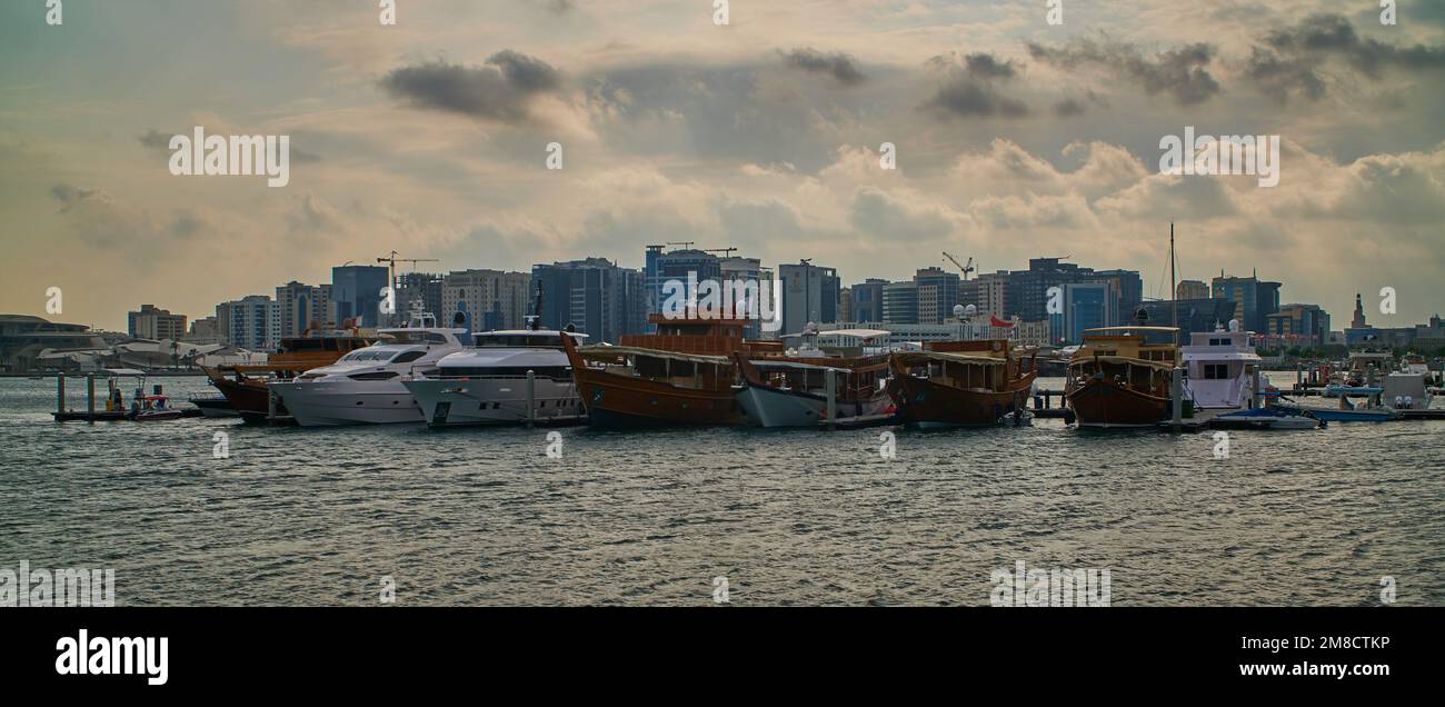 Doha skyline from the box park , Doha Qatar sunset shot with dhows in Arabic gulf and clouds in the sky in background. Stock Photo