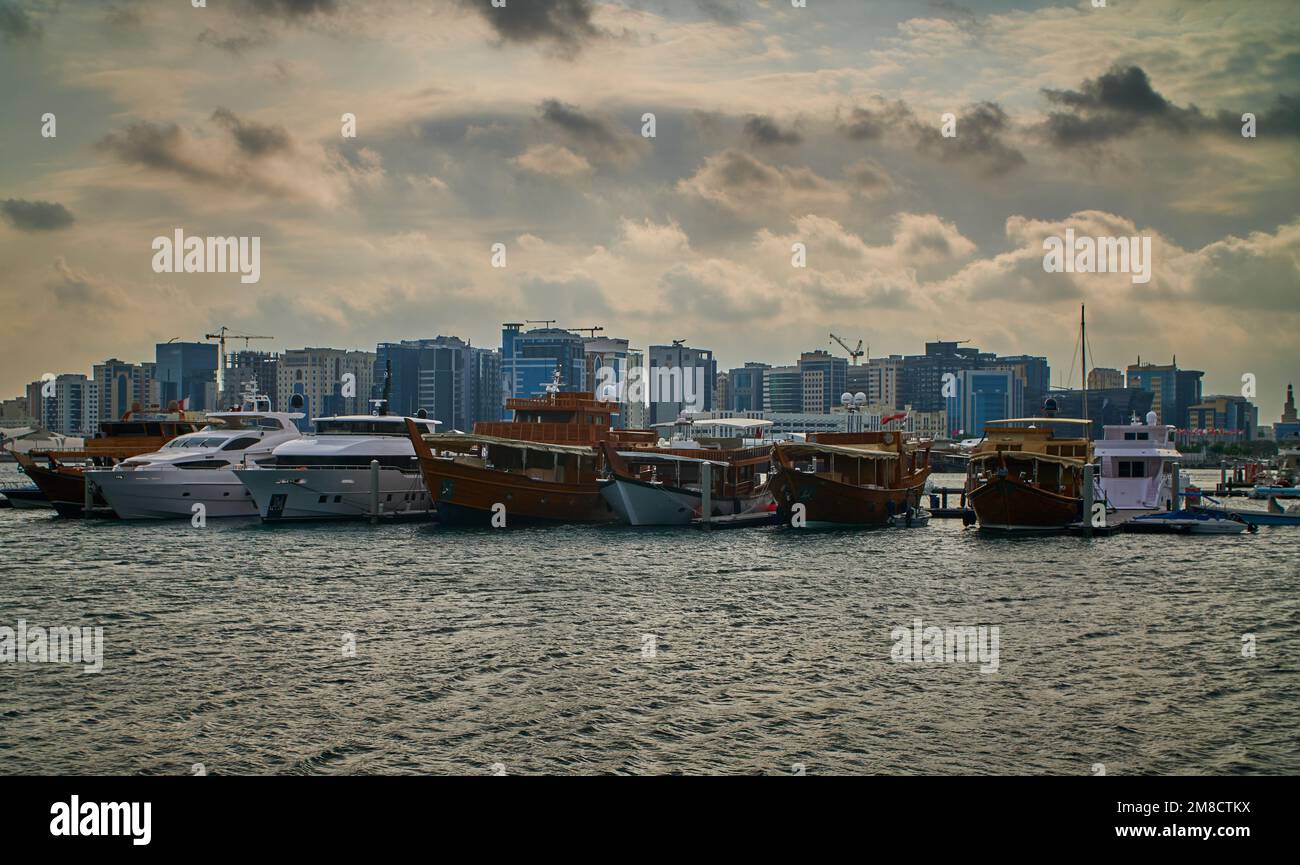 Doha skyline from the box park , Doha Qatar sunset shot with dhows in Arabic gulf and clouds in the sky in background. Stock Photo