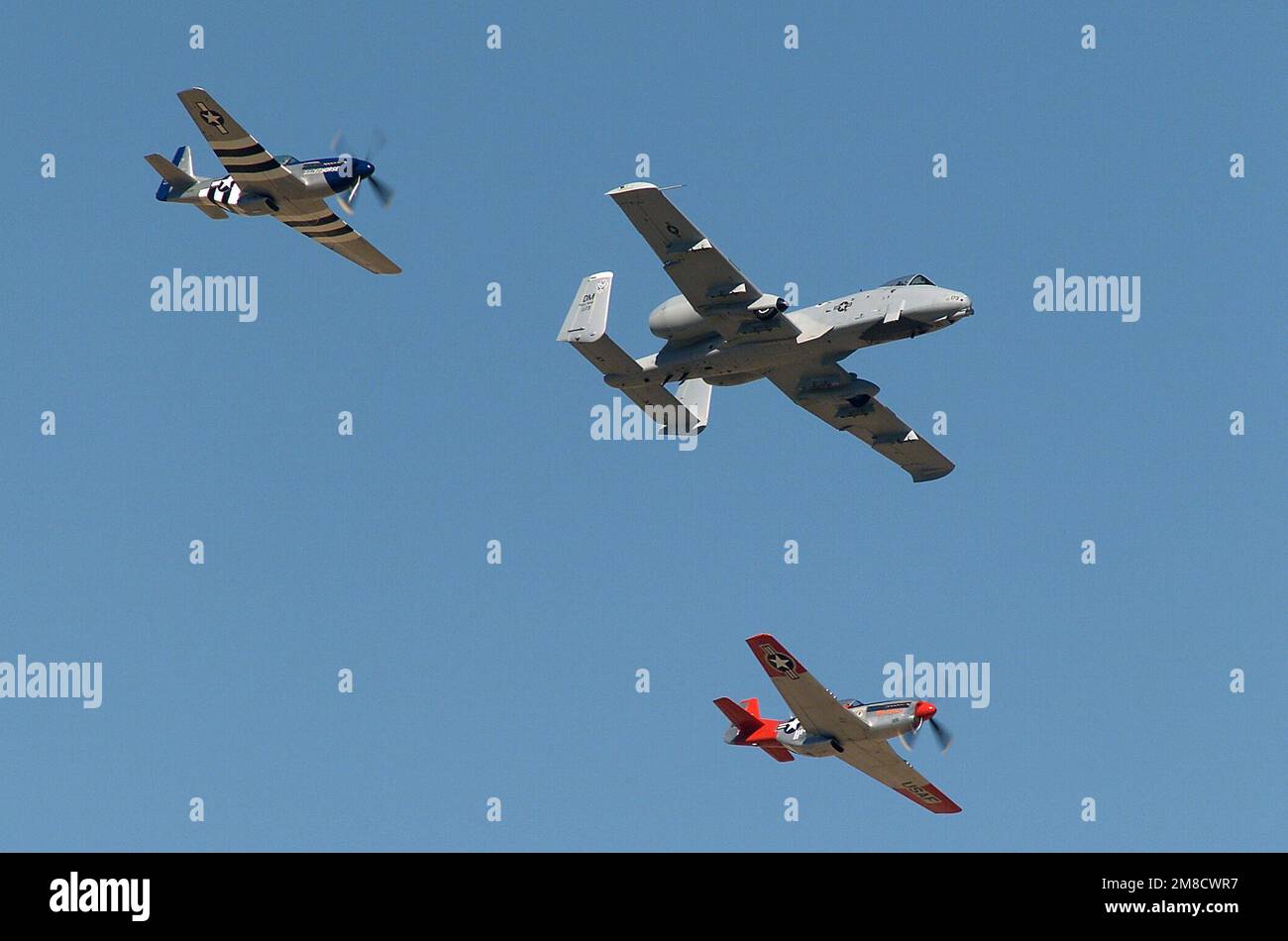 040306-F-3745E-064. Two World War II (WW II) era P-51 Mustang pursuit (fighter) aircraft fly in formation with an US Air Force (USAF) A-10A Thunderbolt II “Warthog” attack aircraft (center) during the Heritage Conference being held at Davis-Montham Air Force Base (AFB), Arizona (AZ). Stock Photo