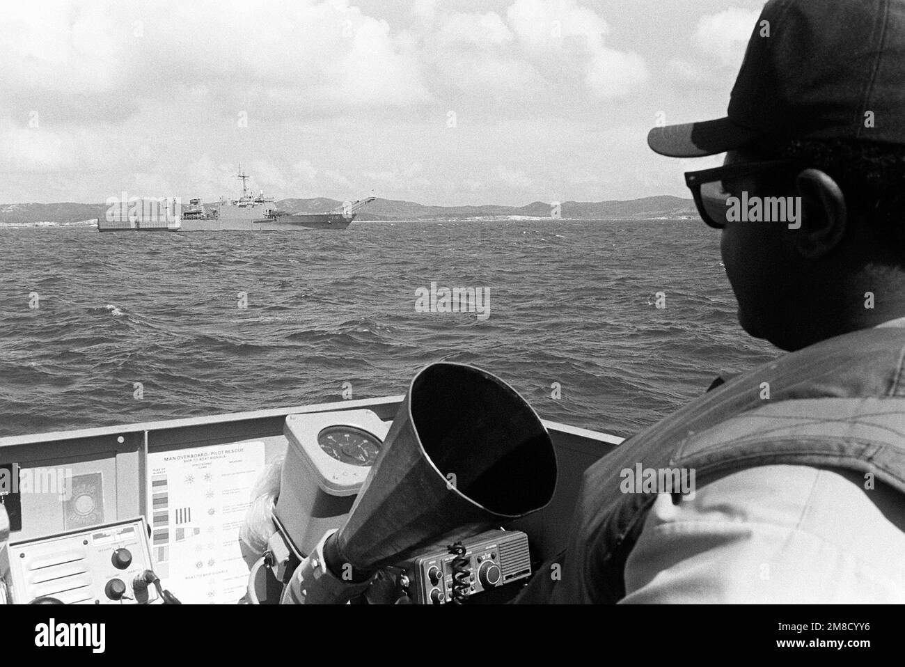 A sailor aboard a utility landing craft (LCU) approaches the tank