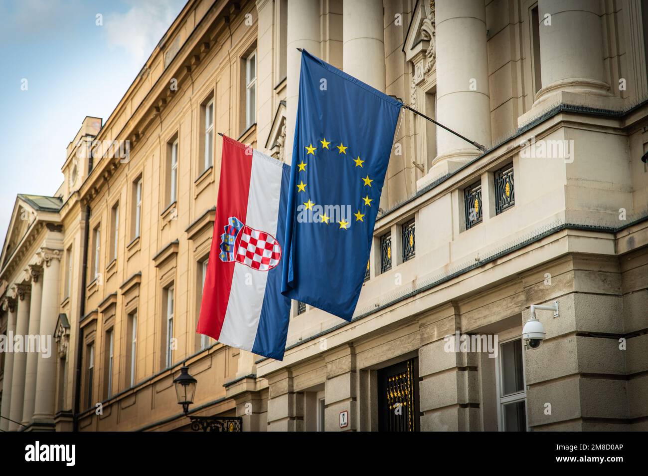 The Croatian and EU flags hanging outside the Croatian Parliament Palace in Zagreb, Croatia Stock Photo