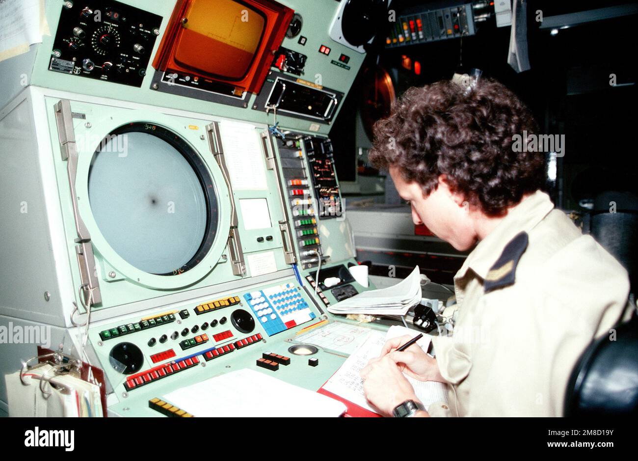 A sailor monitors an air control radar in the operations room aboard ...
