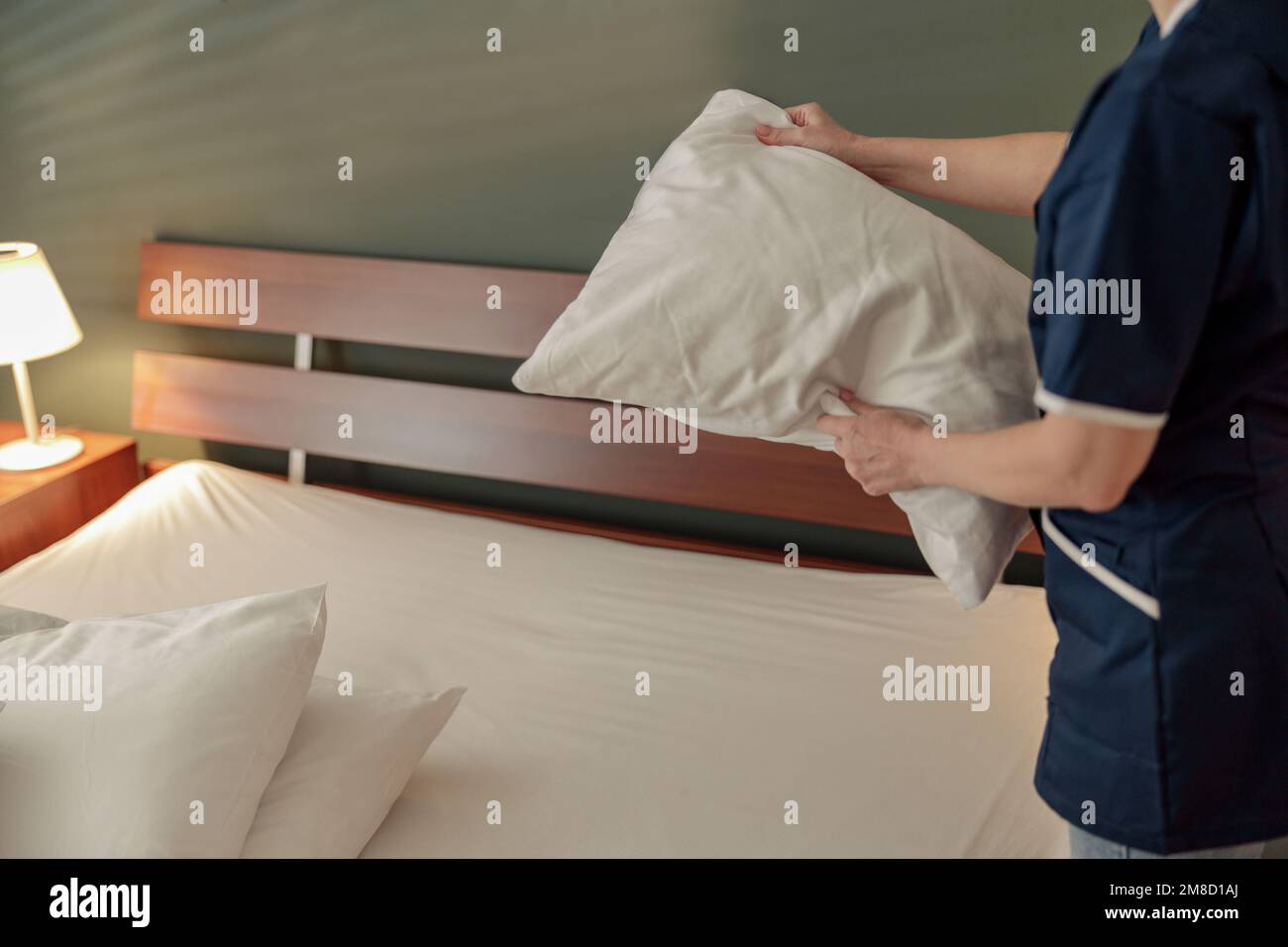 Cleaning lady doing housekeeping and making bed in hotel room. Cleaning service concept Stock