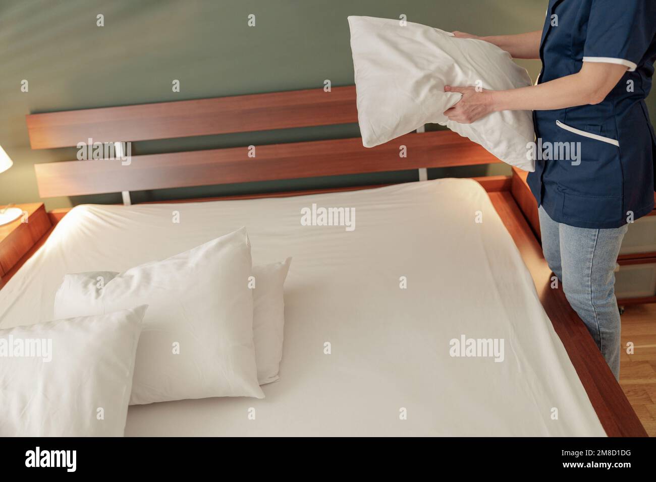 Cleaning lady doing housekeeping and making bed in hotel room. Cleaning