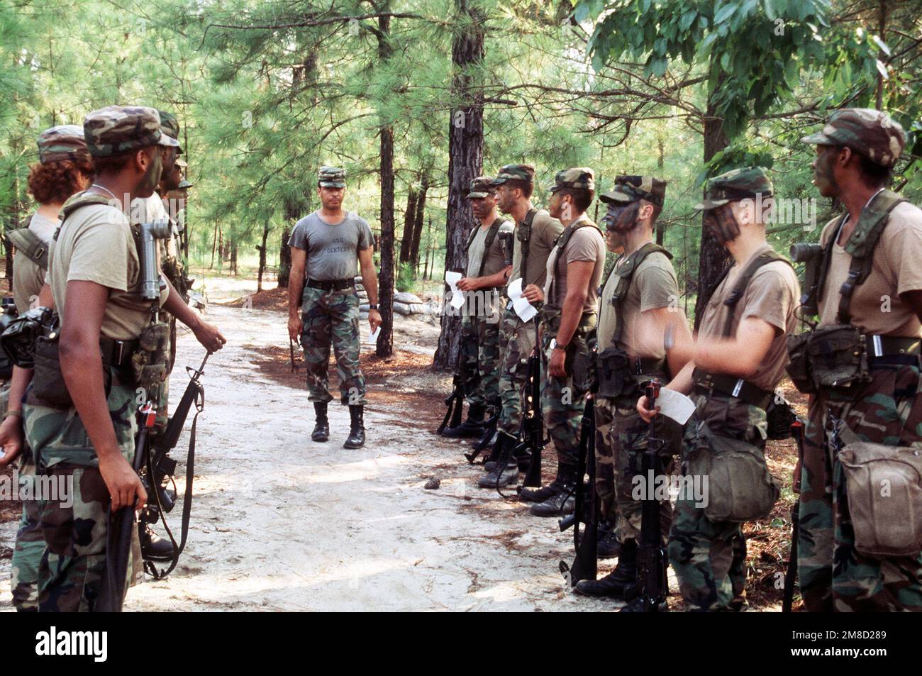 An instructor inspects newly camouflaged recruits during basic training ...