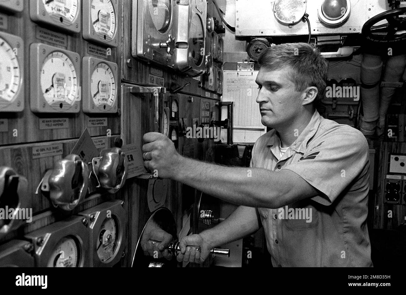 A petty officer works at a control panel for the No. 3 main generator aboard the attack submarine USS BLUEBACK (SS-581). The BLUEBACK, a diesel-electric submarine, is scheduled for decommissioning after more than 30 years of active service. Base: Naval Air Station, San Diego State: California (CA) Country: United States Of America (USA) Stock Photo