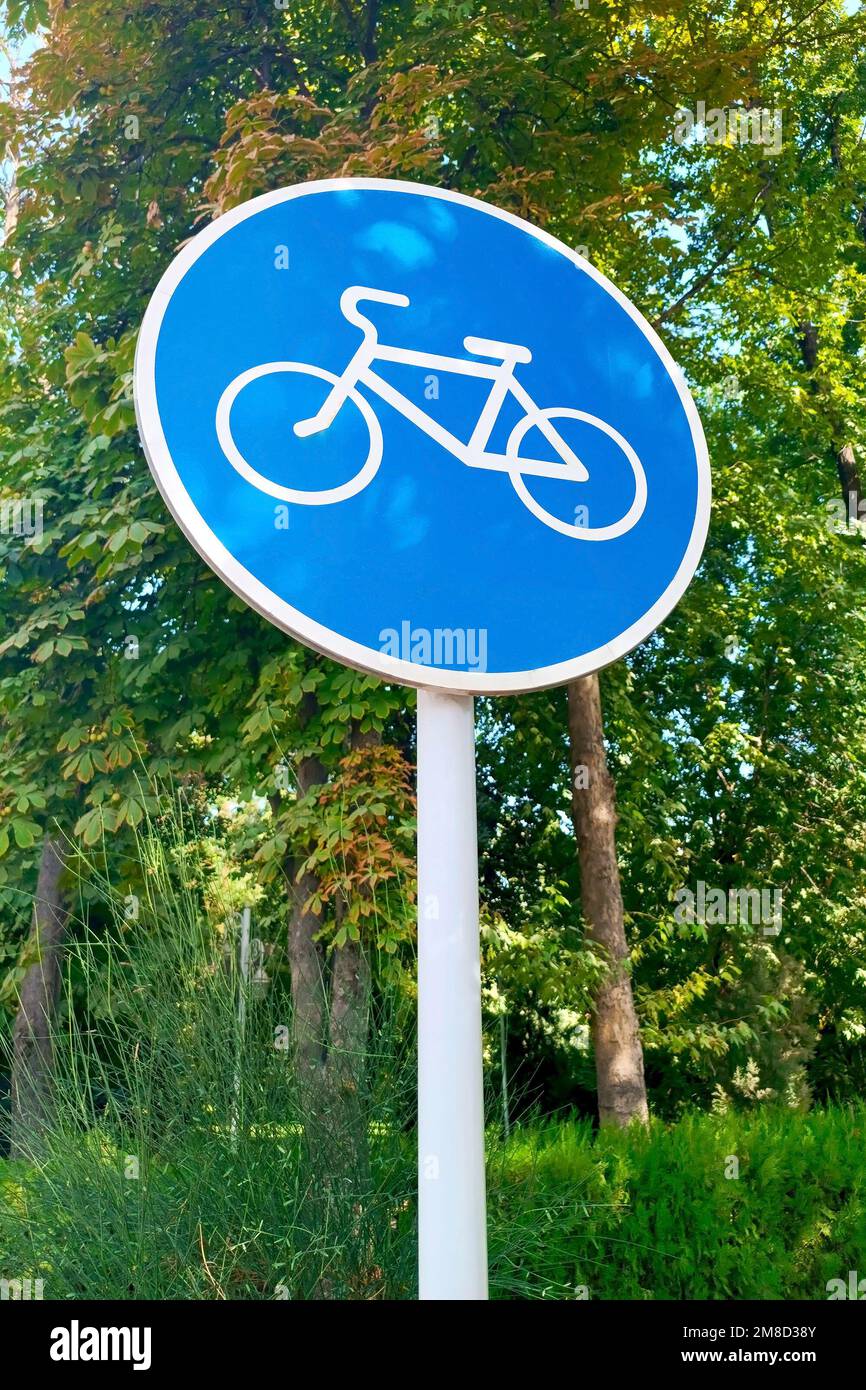 Blue and white bicycle lane sign indicating bike route, large round