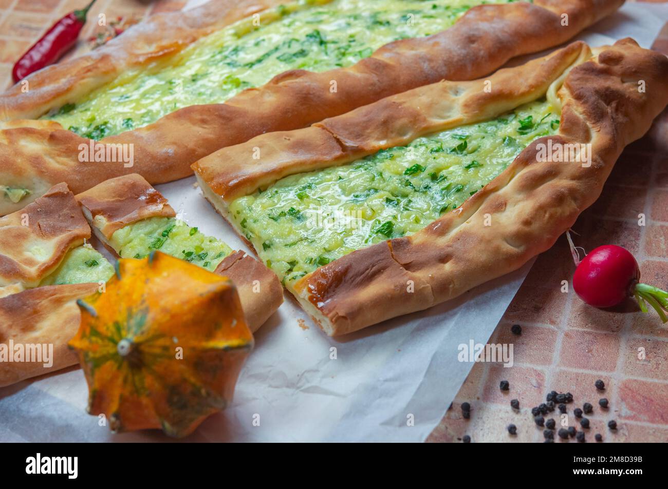Turkish flatbread (pide), close up, copy space for text. Pide is a very delicious dish of Turkish cuisine, which is an open flatbread on yeast dough. Stock Photo