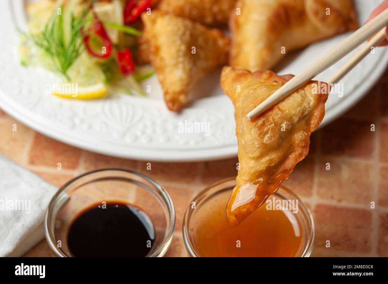 Chinese wontons with sweet chilli dip sauce and chop sticks Asian fried dumplings with soy sauce