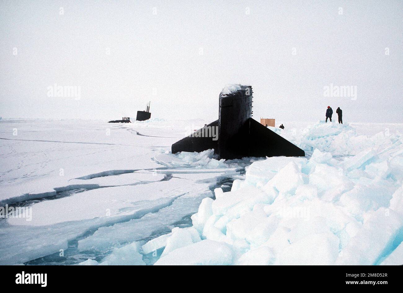 Naval personnel work near the nuclear-powered submarines USS GURNARD ...