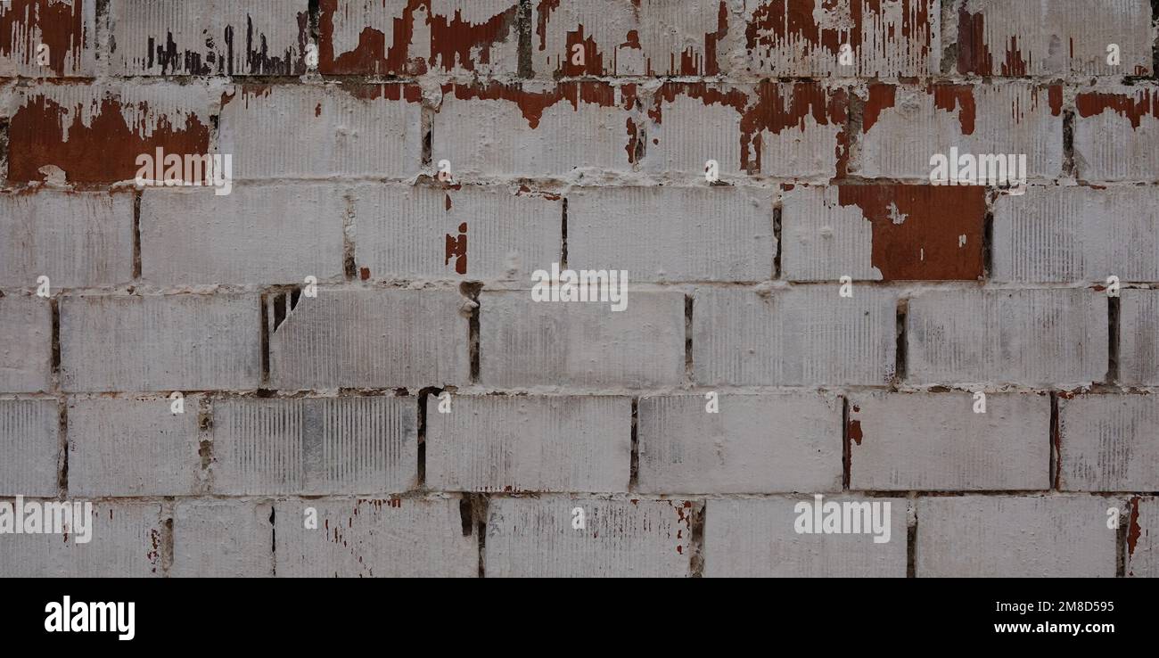 Brick Wall Texture with Cracks. Peeling brick Wall. Background Stock Photo