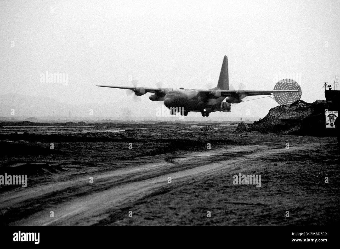 A C130 Hercules aircraft passes over an assault airstrip to make a low
