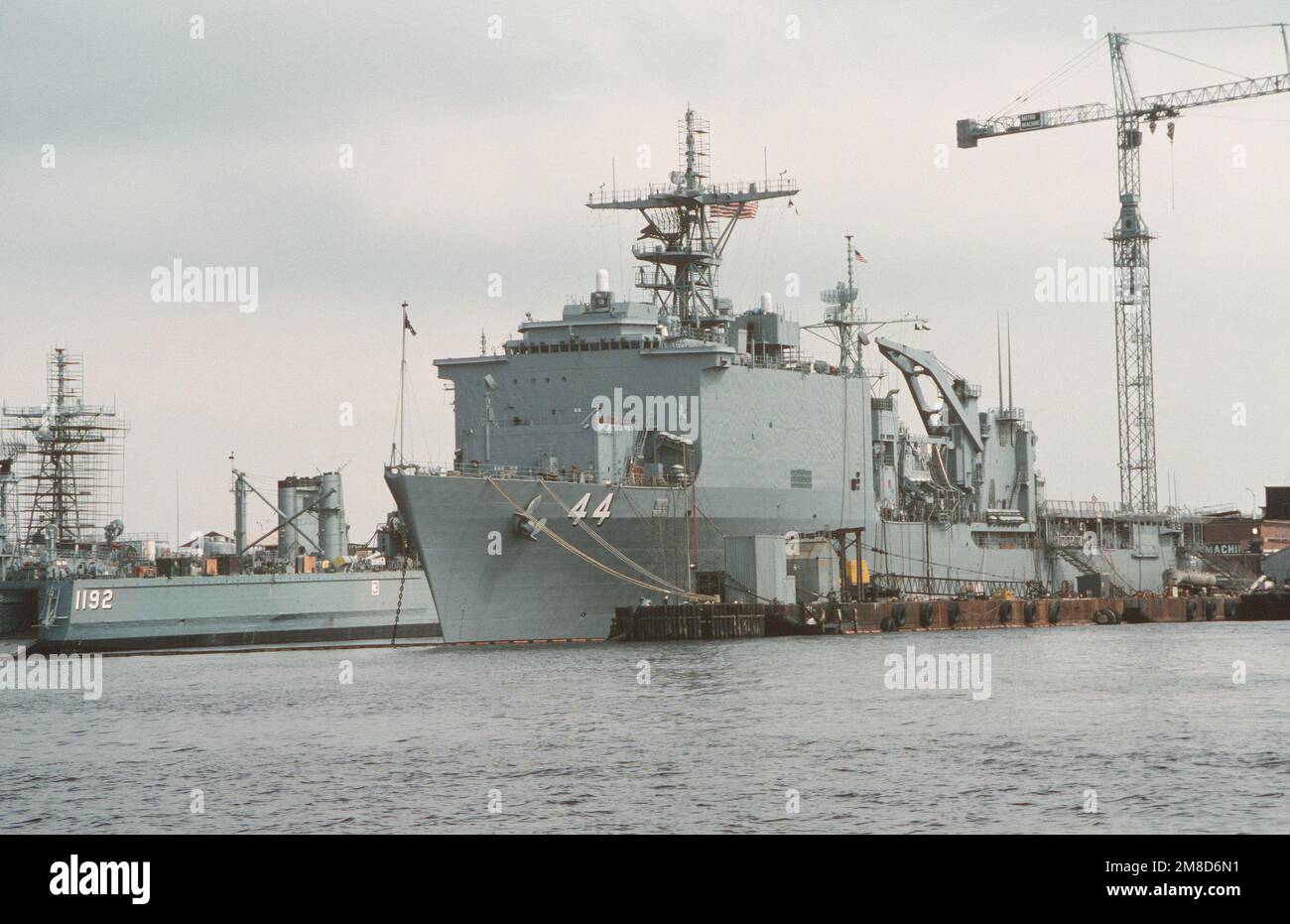 The dock landing ship USS GUNSTON HALL (LSD 44) lies tied up to a pier