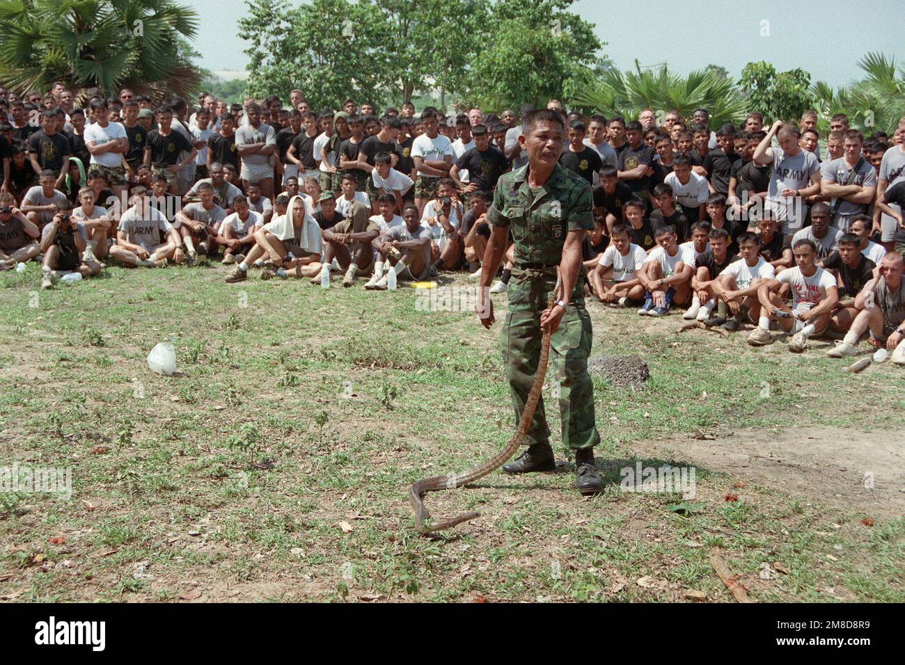 Members of 4th Bn., 22nd Inf., 25th Inf. Div. (Light), watch as a Royal Thai Army instructor teaches a class on the types of dangerous snakes found in Thailand. The 25th Infantry Division soldiers are in Thailand for the combined Thai/U.S. exercise Cobra Gold '90. Subject Operation/Series: COBRA GOLD '90 Base: Chon Buri Country: Thailand (THA) Stock Photo