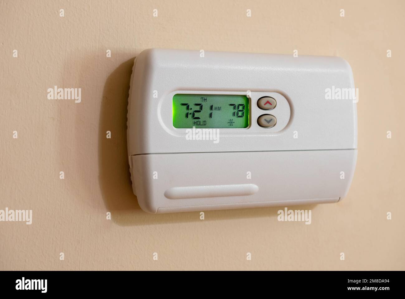 Programmable digital thermostat set to energy saving 78 degrees. Wall mounted temperature controller for home air conditioning and heating system. Stock Photo